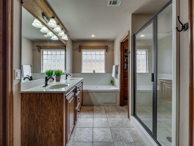 2108 Mulberry Creek Ave, Yukon, OK 73099 - bathroom featuring a bath, double vanity, a stall shower, and recessed lighting