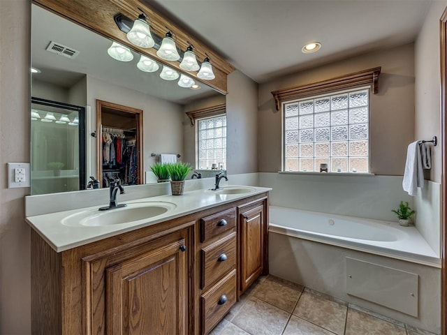 2108 Mulberry Creek Ave, Yukon, OK 73099 - full bathroom with double vanity, a bath, tile patterned flooring, a spacious closet, and recessed lighting