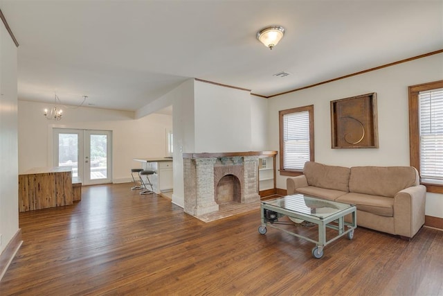 1134 NW 40th St, Oklahoma City, OK 73118 - living room with wood finished floors, a chandelier, french doors, a fireplace, and crown molding