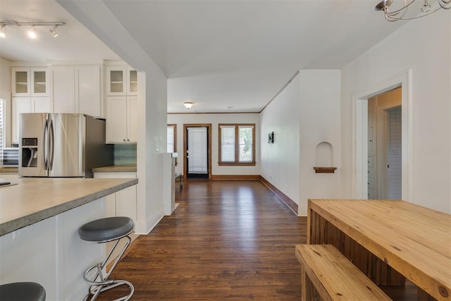 1134 NW 40th St, Oklahoma City, OK 73118 - kitchen featuring stainless steel refrigerator with ice dispenser, dark wood-style flooring, white cabinetry, glass insert cabinets, and light countertops