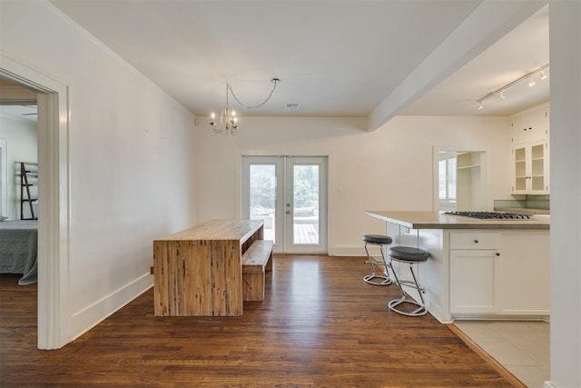 1134 NW 40th St, Oklahoma City, OK 73118 - kitchen featuring french doors, white cabinetry, dark wood-style floors, and a chandelier