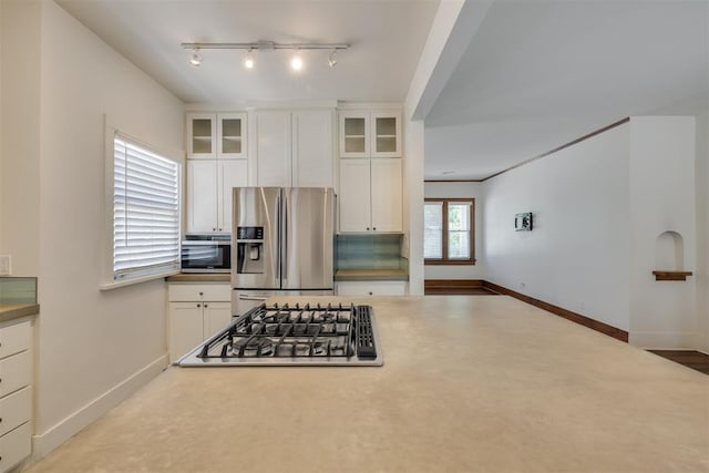 1134 NW 40th St, Oklahoma City, OK 73118 - kitchen featuring appliances with stainless steel finishes, white cabinets, glass insert cabinets, and track lighting