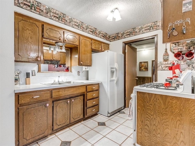 3900 Chetwood Dr, Del City, OK 73115 - kitchen with white appliances, brown cabinetry, a textured ceiling, and light countertops