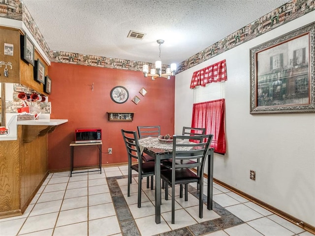 3900 Chetwood Dr, Del City, OK 73115 - dining space featuring a chandelier, light tile patterned flooring, and a textured ceiling
