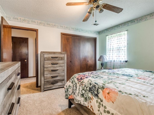 3900 Chetwood Dr, Del City, OK 73115 - bedroom featuring a textured ceiling, light colored carpet, a closet, and ceiling fan