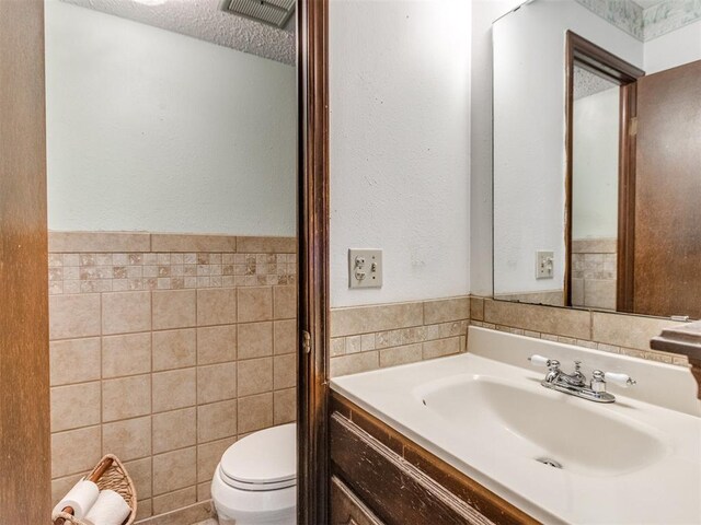 3900 Chetwood Dr, Del City, OK 73115 - bathroom with tile walls, vanity, and a textured ceiling