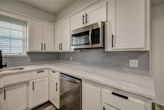 220 E 31st St, Edmond, OK 73013 - kitchen with appliances with stainless steel finishes, tasteful backsplash, and white cabinetry