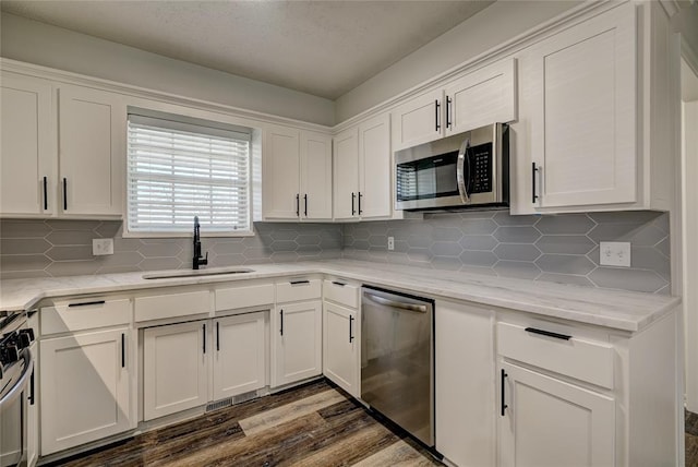 220 E 31st St, Edmond, OK 73013 - kitchen featuring stainless steel appliances, white cabinetry, dark wood finished floors, and decorative backsplash