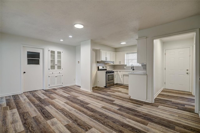 220 E 31st St, Edmond, OK 73013 - kitchen featuring stainless steel gas range oven, dark wood-type flooring, white cabinetry, light countertops, and a textured ceiling