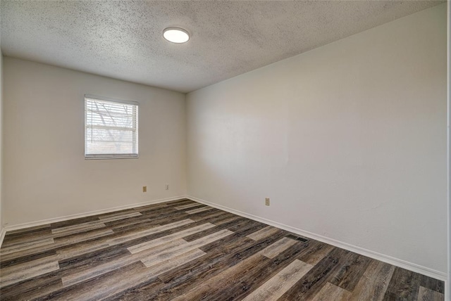 220 E 31st St, Edmond, OK 73013 - empty room with dark wood-style flooring and a textured ceiling
