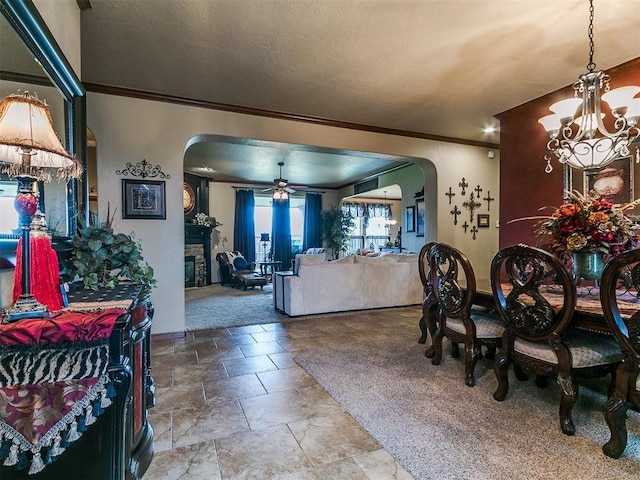 13120 NW 4th St, Yukon, OK 73099 - dining space featuring arched walkways, a chandelier, ornamental molding, ceiling fan, and stone finish floors