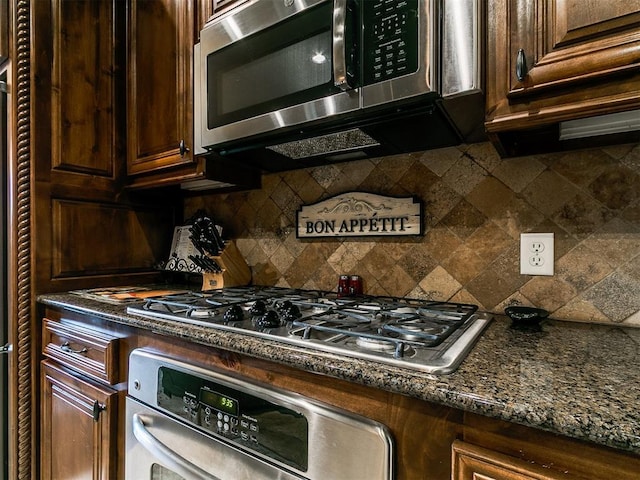 13120 NW 4th St, Yukon, OK 73099 - kitchen with appliances with stainless steel finishes, backsplash, dark stone countertops, and dark brown cabinetry
