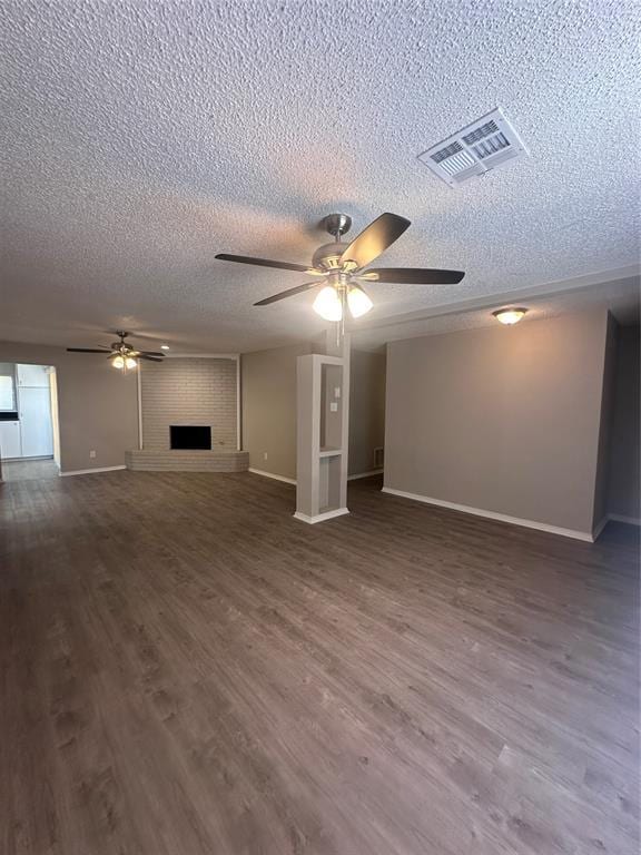 6708 Lyrewood Cir, Oklahoma City, OK 73132 - unfurnished living room featuring a ceiling fan, a textured ceiling, wood finished floors, and a brick fireplace