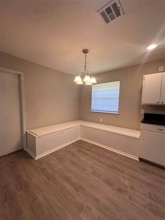 6708 Lyrewood Cir, Oklahoma City, OK 73132 - unfurnished dining area with dark wood-style floors, a chandelier, and recessed lighting