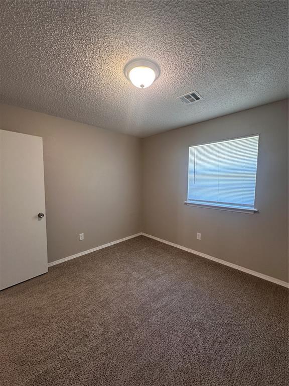 6708 Lyrewood Cir, Oklahoma City, OK 73132 - carpeted empty room featuring a textured ceiling and baseboards