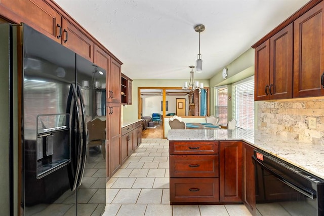 2504 NW 119th St, Oklahoma City, OK 73120 - kitchen featuring black appliances, a peninsula, light stone countertops, light tile patterned flooring, and decorative light fixtures