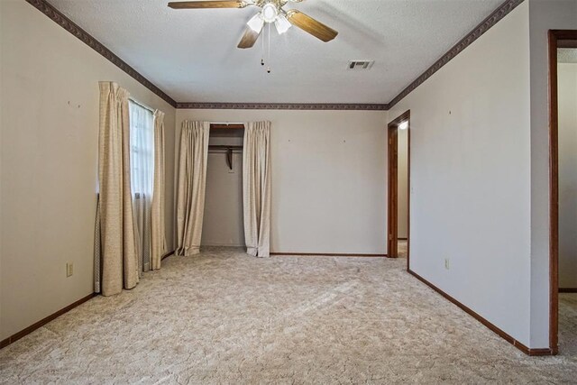 3913 SE 14th Pl, Oklahoma City, OK 73115 - unfurnished bedroom with carpet flooring, a textured ceiling, ornamental molding, ceiling fan, and a closet