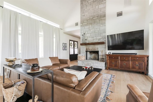501 Old Creek Rd, Edmond, OK 73034 - living area with high vaulted ceiling, light wood-style flooring, and a stone fireplace
