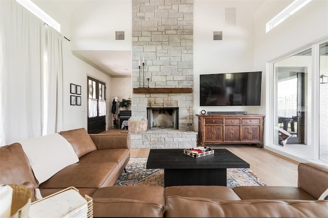 501 Old Creek Rd, Edmond, OK 73034 - living area with a high ceiling, light wood-type flooring, a fireplace, and ornamental molding