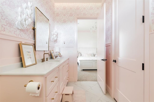 501 Old Creek Rd, Edmond, OK 73034 - bathroom featuring wallpapered walls, wainscoting, marble finish floors, vanity, and ensuite bathroom
