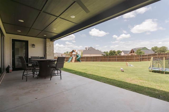 501 Old Creek Rd, Edmond, OK 73034 - fenced backyard with a trampoline, a playground, a patio, and outdoor dining space