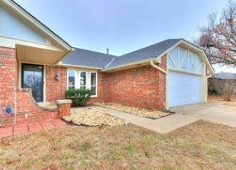 2912 Smiling Hill Blvd, Edmond, OK 73013 - view of front of home with brick siding, driveway, and a garage