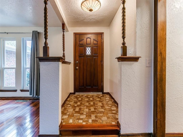 2912 Smiling Hill Blvd, Edmond, OK 73013 - foyer entrance featuring a textured ceiling, a textured wall, and wood finished floors