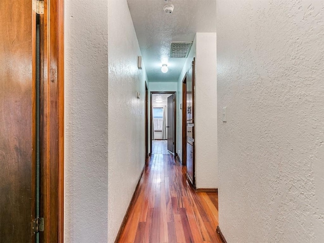2912 Smiling Hill Blvd, Edmond, OK 73013 - corridor with a textured wall and hardwood / wood-style floors
