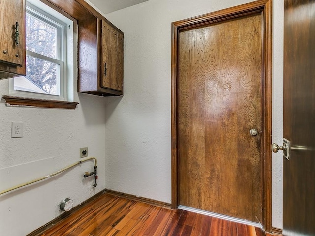 2912 Smiling Hill Blvd, Edmond, OK 73013 - laundry room featuring dark wood-type flooring, cabinet space, hookup for an electric dryer, a textured wall, and gas dryer hookup
