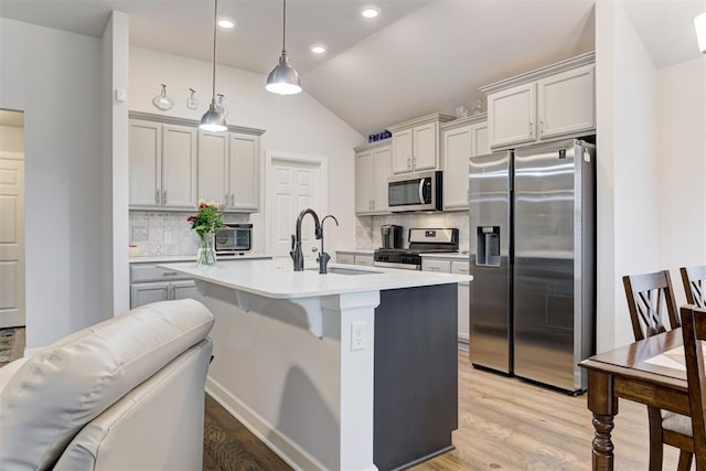 2161 Native Dancer Dr, Choctaw, OK 73020 - kitchen featuring stainless steel appliances, lofted ceiling, decorative backsplash, light wood-type flooring, and light countertops