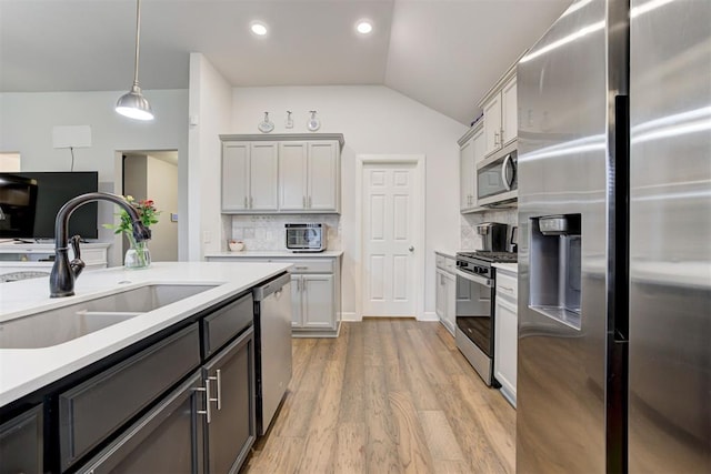 2161 Native Dancer Dr, Choctaw, OK 73020 - kitchen with stainless steel appliances, lofted ceiling, light countertops, tasteful backsplash, and light wood-style flooring