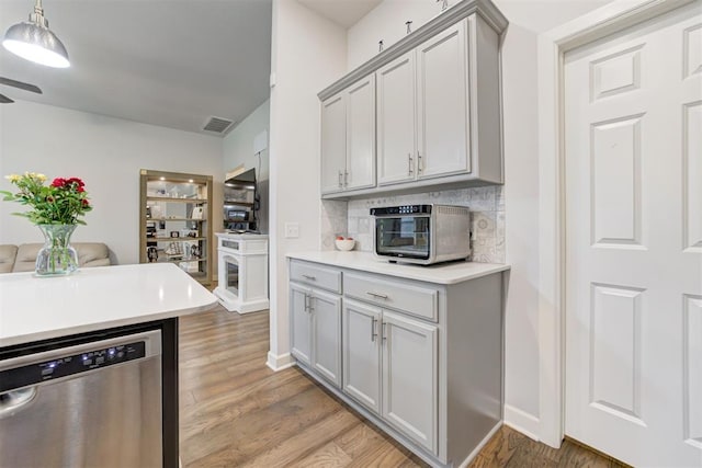 2161 Native Dancer Dr, Choctaw, OK 73020 - kitchen featuring stainless steel dishwasher, decorative backsplash, light wood-style floors, light countertops, and gray cabinetry