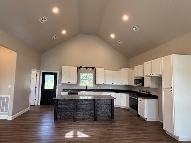 379100 E 1100th Rd, Okemah, OK 74859 - kitchen with stainless steel appliances, high vaulted ceiling, a center island, dark wood-style floors, and white cabinets