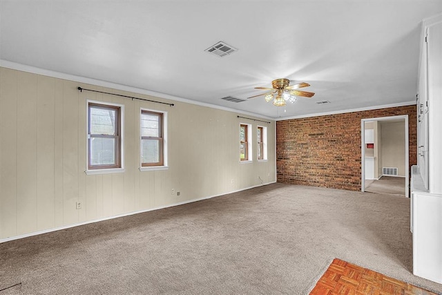 908 S Trail Dr, Altus, OK 73521 - carpeted empty room featuring ceiling fan, crown molding, and brick wall