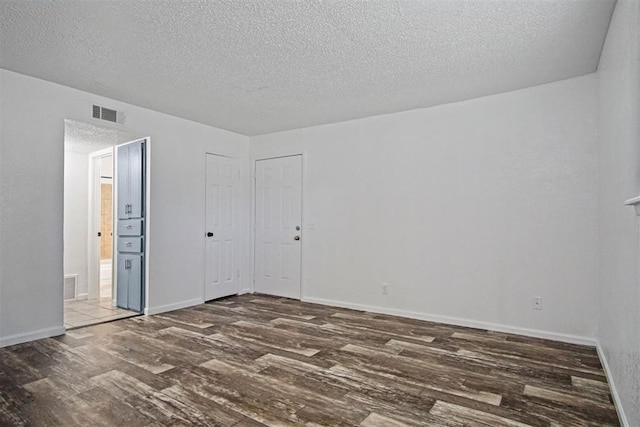 6220 S Douglas Ave, Oklahoma City, OK 73139 - spare room featuring wood finished floors and a textured ceiling