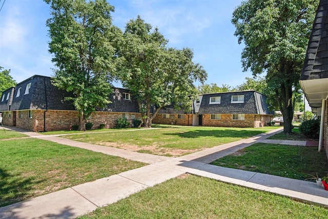 6220 S Douglas Ave, Oklahoma City, OK 73139 - view of front of home featuring mansard roof, a front lawn, and brick siding
