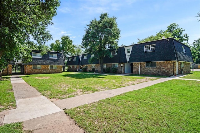 6220 S Douglas Ave, Oklahoma City, OK 73139 - dutch colonial featuring a front yard, roof with shingles, brick siding, and mansard roof