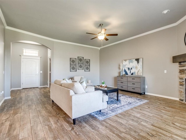 7313 Jack Dr, Oklahoma City, OK 73132 - living room with arched walkways, ceiling fan, wood finished floors, ornamental molding, and a stone fireplace