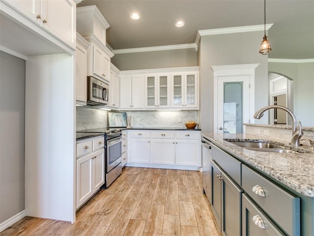 7313 Jack Dr, Oklahoma City, OK 73132 - kitchen featuring stainless steel appliances, white cabinets, crown molding, light wood-type flooring, and hanging light fixtures
