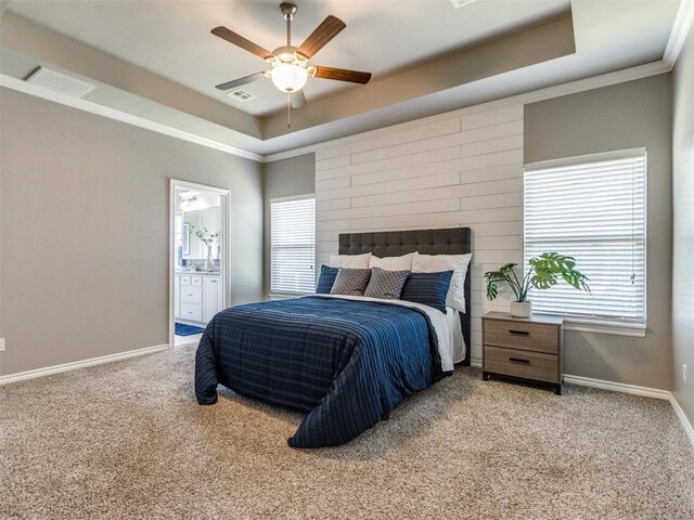 7313 Jack Dr, Oklahoma City, OK 73132 - carpeted bedroom with a raised ceiling, multiple windows, ensuite bathroom, ceiling fan, and crown molding