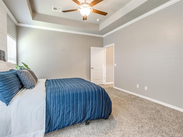 7313 Jack Dr, Oklahoma City, OK 73132 - bedroom featuring a tray ceiling, carpet flooring, a ceiling fan, and crown molding