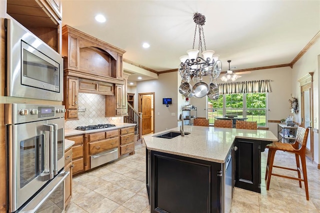227 Quail Hollow Way, Choctaw, OK 73020 - kitchen with appliances with stainless steel finishes, a warming drawer, crown molding, decorative backsplash, and a center island with sink