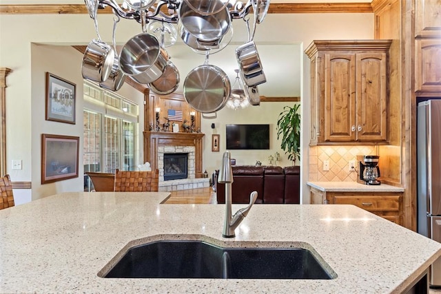 227 Quail Hollow Way, Choctaw, OK 73020 - kitchen featuring a chandelier, decorative backsplash, light stone counters, freestanding refrigerator, and crown molding