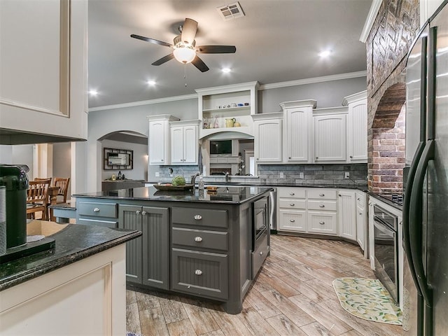 2395 County Road 1260, Blanchard, OK 73010 - kitchen featuring freestanding refrigerator, arched walkways, ceiling fan, gray cabinets, and backsplash