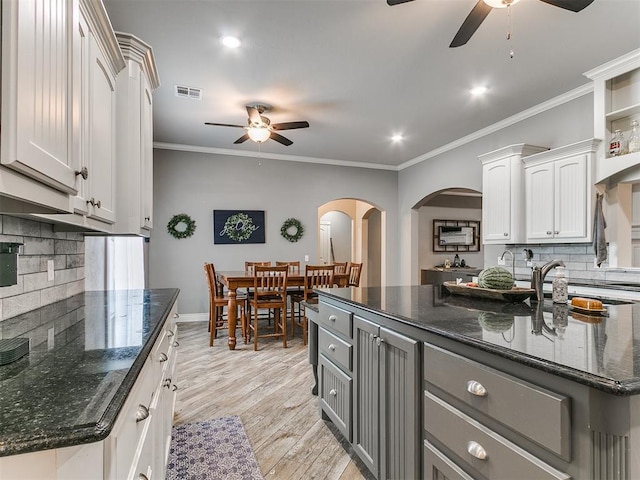 2395 County Road 1260, Blanchard, OK 73010 - kitchen with ceiling fan, decorative backsplash, arched walkways, ornamental molding, and white cabinetry