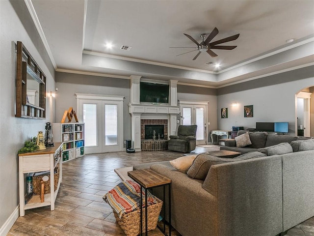2395 County Road 1260, Blanchard, OK 73010 - living area with a ceiling fan, a tray ceiling, plenty of natural light, crown molding, and a brick fireplace