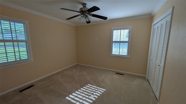 3957 N 58th Ter, Oklahoma City, OK 73112 - unfurnished bedroom featuring multiple windows, crown molding, light colored carpet, a closet, and ceiling fan