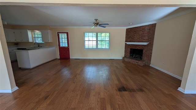 3957 N 58th Ter, Oklahoma City, OK 73112 - unfurnished living room with ceiling fan, a fireplace, dark wood-style flooring, and ornamental molding