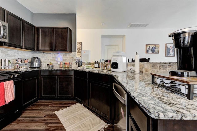 11704 NW 135th Ter, Piedmont, OK 73078 - kitchen with gas stove, a peninsula, light stone counters, tasteful backsplash, and dark wood-type flooring