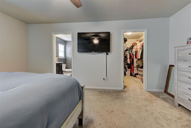 11704 NW 135th Ter, Piedmont, OK 73078 - carpeted bedroom with a walk in closet, connected bathroom, a closet, and ceiling fan